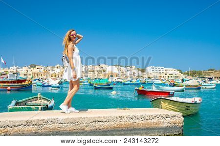 May 03, 2018. Marsaxlokk, Malta. Beautiful Girl Exploring Amazing Marsaxlokk Fishing Village With Ma