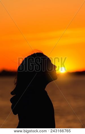 Silhouette Of A Girl Against The Evening Sun Red Sunset, Facing The Sun