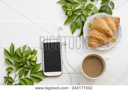 Hot Coffee With Dessert Snack And Mobile Phone Purple Flower Arrangement On Background White Wooden