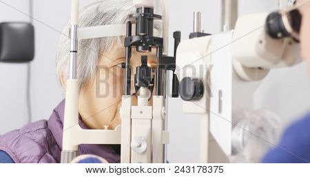 Asian Old woman checking on eye 