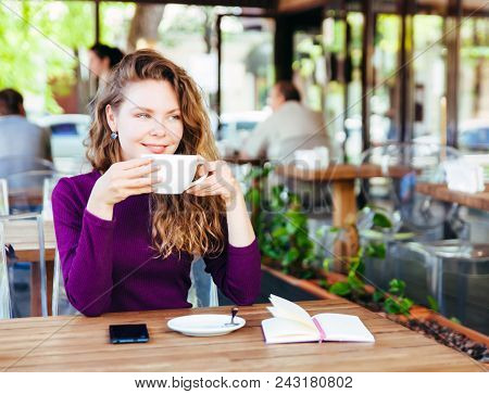 Beautifl Attractive Young Blonde Woman With Curly Hair Drinking Cappuccino In City Cafe Summer Day. 