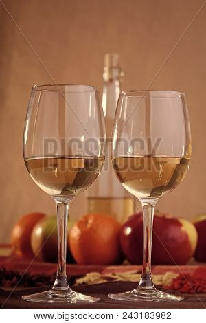 Pair Of Transparent Glasses Half Filled With White Sweet Amber Wine With Open Incomplete Bottle Ripe