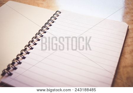 Spiral Notebook On The Abstract Wooden Table