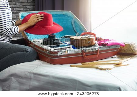Travel And Vacation Concept, Happiness Woman Packing Stuff And A Lot Of Clothes Into Suitcase On Bed