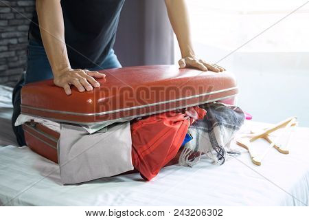 Travel And Vacation Concept, Happiness Young Man Packing A Lot Of His Clothes And Stuff Into Suitcas
