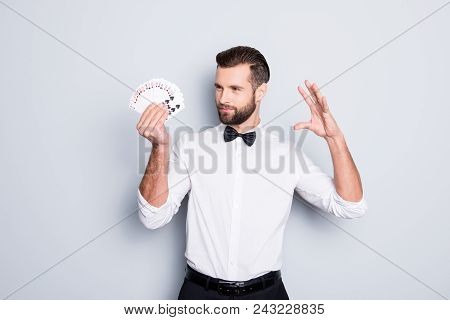 Portrait Of Cunning Foxy Magician With Modern Hairstyle And Stubble In White Shirt With Bowtie Holdi