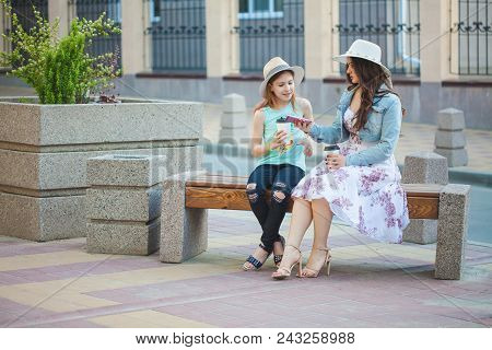 Two Sisters, A Beautiful Brunette Girl And A Young Girl Walking In The City, Sitting On A Bench And 