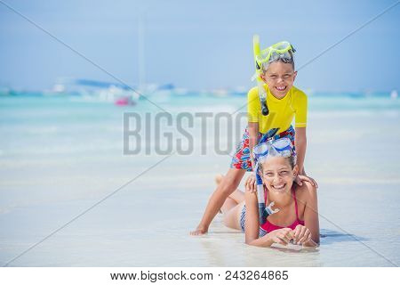 Brother And Sister Playing And Having Fun On The Beach During The Hot Summer Vacation Day.