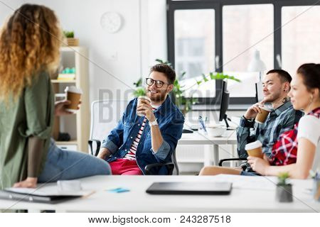 business and people concept - happy creative team drinking coffee at office