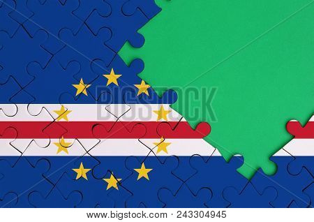 Cabo Verde Flag  Is Depicted On A Completed Jigsaw Puzzle With Free Green Copy Space On The Right Si
