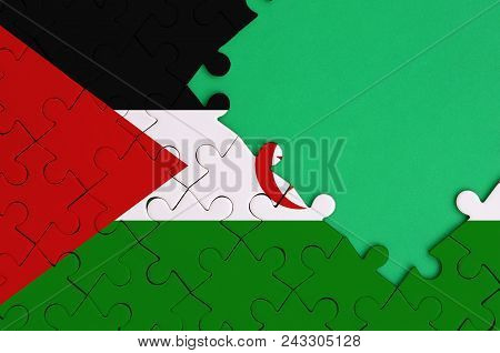 Western Sahara Flag  Is Depicted On A Completed Jigsaw Puzzle With Free Green Copy Space On The Righ