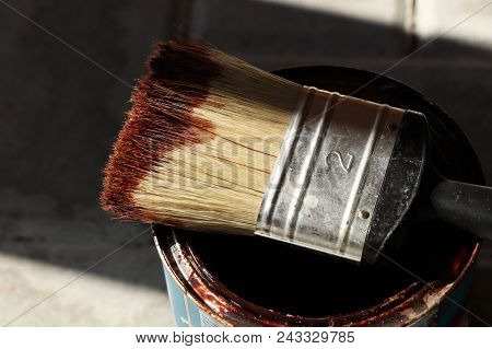 A Brush For Painting Wood And Some Wooden Boards With Paint On The Can
