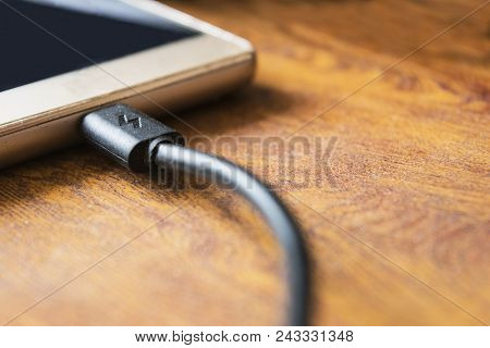 Charger Plug Phone On Wooden Table Background