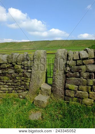 A Dry Stone Wall With Stone Stile Or Narrow Gate With Steps In A Yorkshire Dales Hillside Meadow Wit