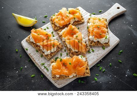 Homemade Crispbread Toast With Smoked Salmon And Soft Chees, Chives On White Board.