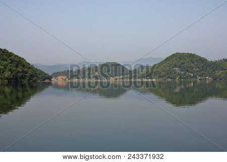 Morning Scene At Begnas Lake, Nepal. Hills Covered By Forest Mirroring In The Water, View From Majhj