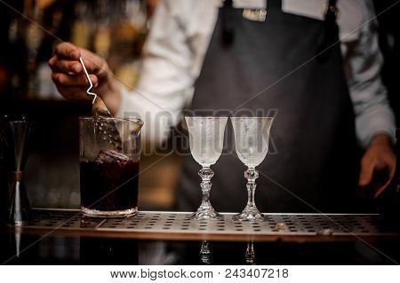 Bartender Making A Fresh And Sweet Summer Cocktail And Pouring It Into Two Glsses On Bar Counter