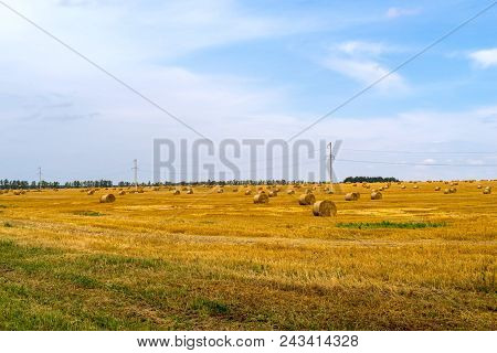 Agricultural Landscape Of The Field With Straw Bales After Harvesting Of Cereals And The Sky With Cl