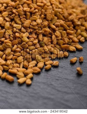 Fragrant Grains Of Fenugreek On A Rustic Background.