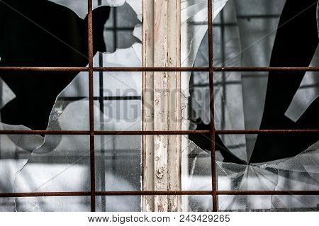 Smashed Glass Window With Old Wooden Frame On Grunge Wall Damaged House