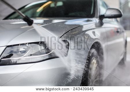 Detail On Car Front Being Washed With Jet Water In Carwash.