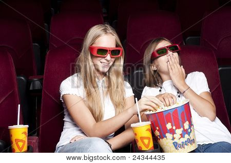 Zwei schöne Mädchen, die einen Film im Kino