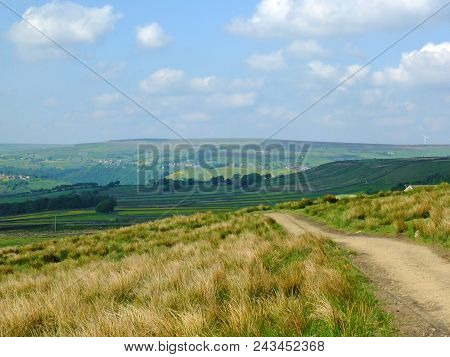 A Long Footpath Running Downhill In Stoodley Moor In Yorkshire With Fields And Farms In The Distance