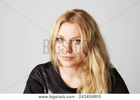 Close Up Shot Of Attractive Young Woman Looking Against Gray Background. Beautiful Female Model With