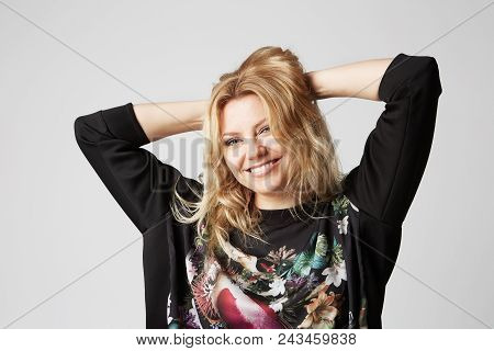 Beautiful Happy Blonde Women Touching Her Hair Hands And Smiling, On Gray Background. Studio Shot.