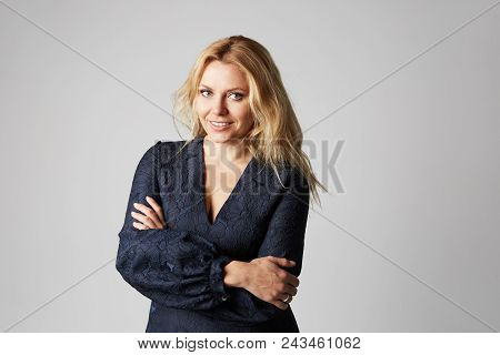 Fashion Photo Of A Beautiful Blonde Woman In A Pretty Dress Posing Over Gray Empty Background. Fashi