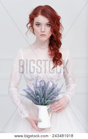 Tender Retro Portrait Of A Young Beautiful Dreamy Redhead Woman In Beautiful White Dress With Bouque