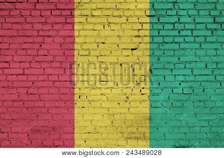 Guinea Flag Is Painted Onto An Old Brick Wall