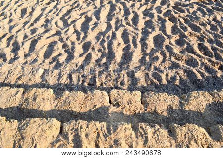 Old Ancient Yellow Stone Steps Covered With Brown Friable Sand With Waves And Irregularities, Descen