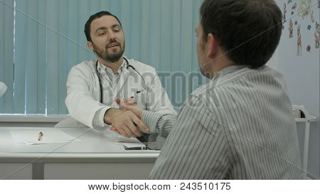 Male Bearded Doctor In Clinic With Male Patient Happyly Shake