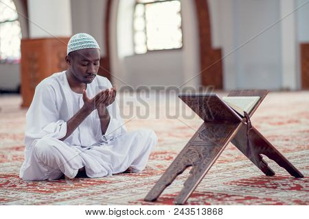 African Muslim Man Making Traditional Prayer To God While Wearing Dishdasha.
