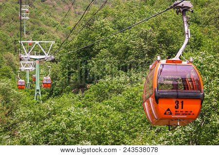 Mutianyu, Huairou, China - May 7, 2018: Cab Of Orange Colour Of Cableway On The Background Of Mounta