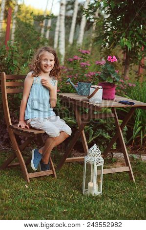 Happy Romantic Child Girl Dreaming In Evening Summer Garden Decorated With Candle Holder.