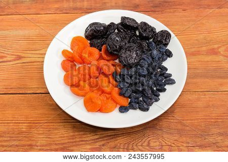 Traditional Dried Fruits - Dark-colored Raisins, Dried Plums And Dried Apricots On The White Dish On