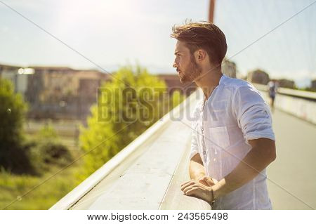 One Attractive Young Man In Urban Setting In Modern City, Leaning Against Balusters