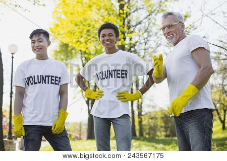 Involve In Nature. Jolly Three Volunteers Laughing And Wearing Gloves