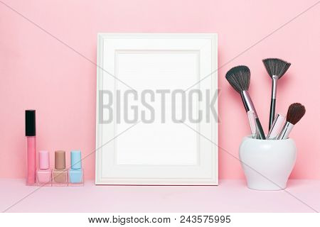 Mock Up Frame And Nail Polishes With Make Up Brushes And Accessorises Women's Table With Pink Backgr