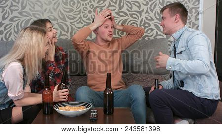 Students Sitting Behind Table, Drinking Beer And Telling Funny Story