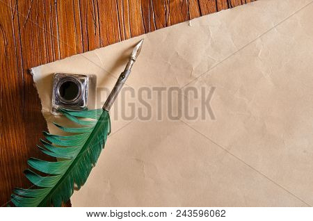 Green Quil Pen And Black Inkwell With Old Papers And Books