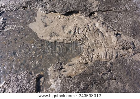 Flow Of Water With Lumps Snow Melts On The Road In The City