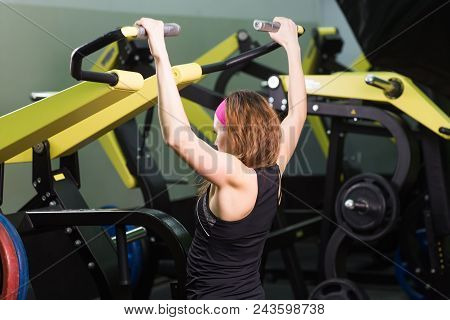 Sport, Fitness, Lifestyle And People Concept - Close Up Of Young Woman Flexing Muscles On Cable Gym 