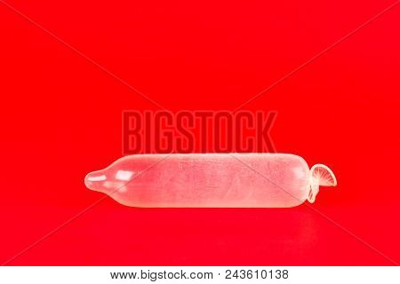 Used Condom On Red Background. Used Condom