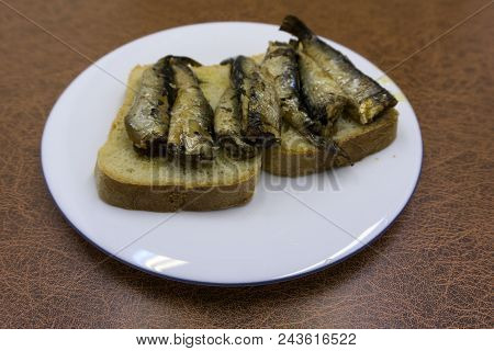 Sandwich With Sprats And Cheese On Wooden Cutting Board