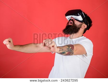 Man With Beard In Vr Glasses Driving Motorbike, Red Background. Hipster On Excited Face Driving Bike