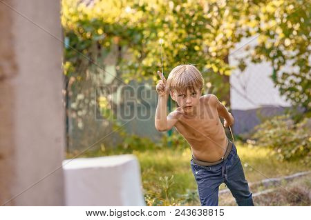 Concentrated Sporty Young Boy Training With Throwing Knife