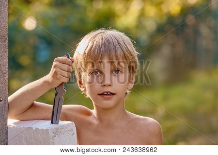 Portrait Of Young Smiling Athletic Boy With Throwing Knife